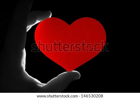 hand keep heart on a black background