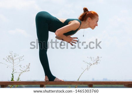 Picture of young fitness lady outdoors in the beach make yoga stretching exercises. Portrait