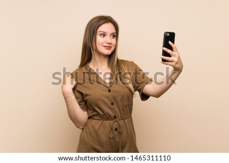 Teenager girl over isolated background making a selfie