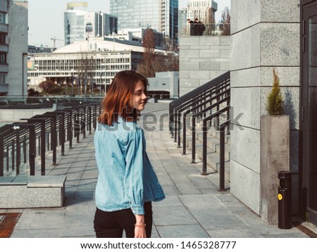 Girl wearing t-shirt and cotton jacket posing against street , urban clothing style. Street photography