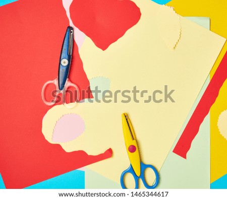  pair of plastic scissors and colored paper for cutting figures, application and scrapbooking