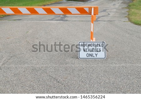 Authorized Vehicles Only Sign on Street with a Bright Orange and White Safety Barricade to Block Traffic from Driving on Road
