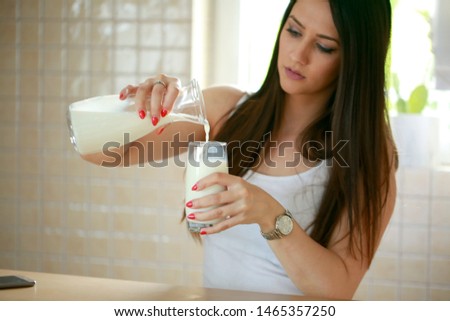 Woman pouring milk from a bottle stock photo