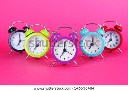 Colorful alarm clock on pink background