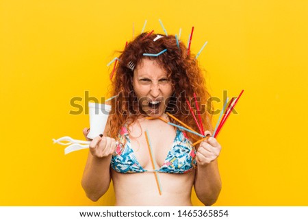 Young caucasian redhead woman angry with the abusive use of plastic