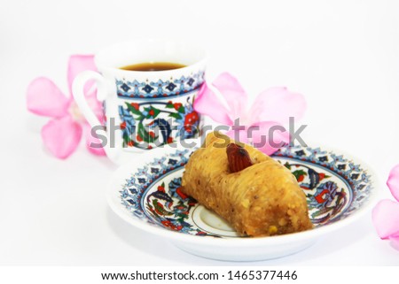 Eastern Turkish traditional sweet baklava on a colorful plate and a cup of coffee