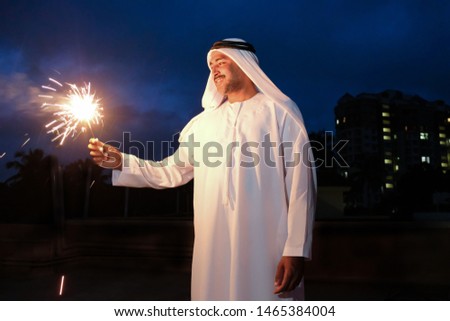 An arab young man enjoying the sparkle of the festivity during festival celebration. Royalty-Free Stock Photo #1465384004