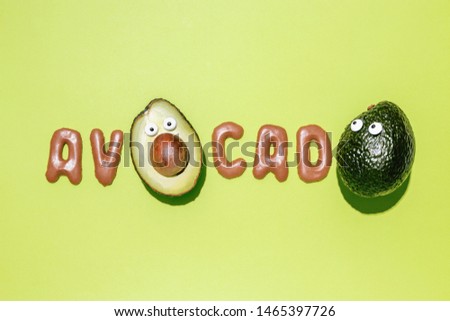 Avocado word made with hass avocados and biscuits on a green background, creative flat lay healthy food concept