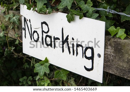 Rustic handmade do it yourself No Parking sign on a worn wooden fence