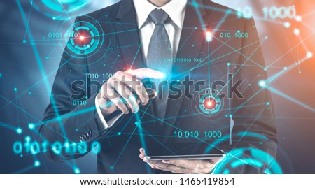 Businessman using tablet computer over blurred background with double exposure of HUD interface and binary numbers. Concept of future technology. Toned image