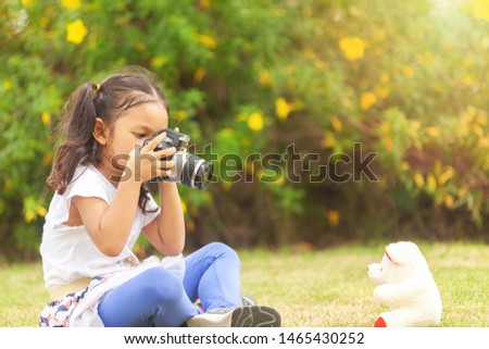 Asian children take pictures of teddy bears in the garden