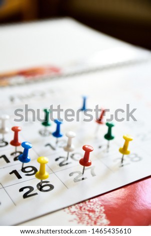 Thumbtack in calendar concept for important date or busy day, appointment and meeting reminder.
Pushpin with busy day overworked schedule.