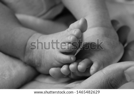 Baby feet held by mother