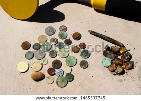 The photo of gold and silver  coins collected with help of underwater metal detector. Treasure searching and tourist adventure background.