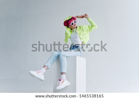 stylish woman in green jacket sitting