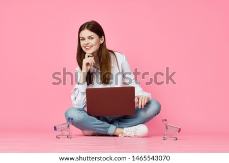 woman with laptop on pink background