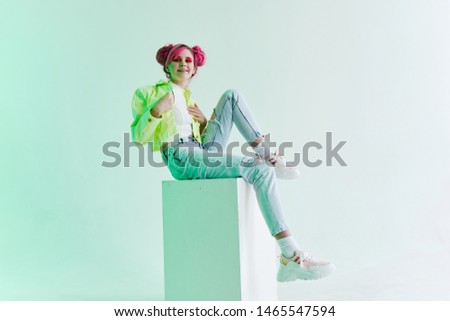 neon woman with pink hair sits on a cube