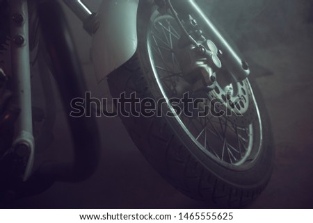 motorcycle front wheel shrouded in smoke.