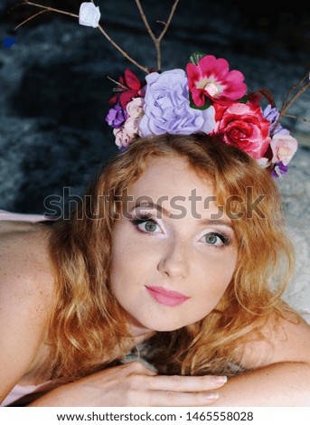 Portrait of a beautiful red-haired girl with a floral decor on her head. Forest nymph, fantastic character, postcard, poster, calendar.