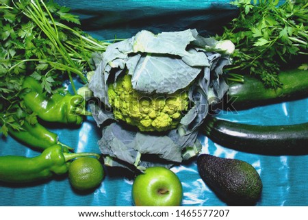 still life of green fresh vegetables on a turquoise background
