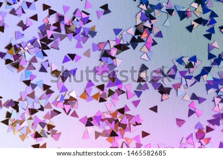 Abstract background of multicolored confetti in neon light. Selective focus.