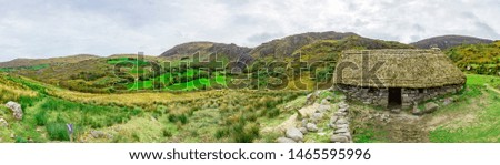 Panorama picture of typical Irish landscape with medieval stone house 