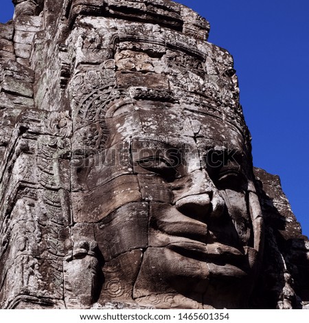 Fragment of the ancient stone temple Bayon in Cambodia. Stone face. The face of a man, folded with stone blocks.