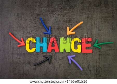 Change management, business transformation or move before disruption concept, multi color magnet arrows pointing to the word CHANGE at the center of dark black cement chalkboard wall background.