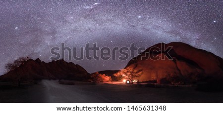 Camping under the milky way stars with a camp fire in Spitzkoppe, Namibia