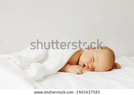 Beautiful baby sleeps on the bed in white sheets. Royalty-Free Stock Photo #1465637585