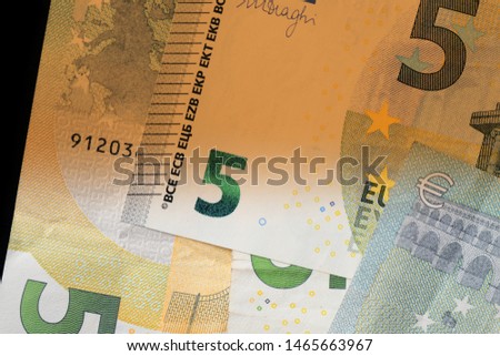 Five euro banknotes on a dark background close up. Money background brown color toned