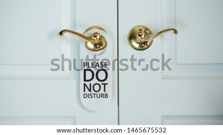 White door of a hotel room with a sign Do not disturb