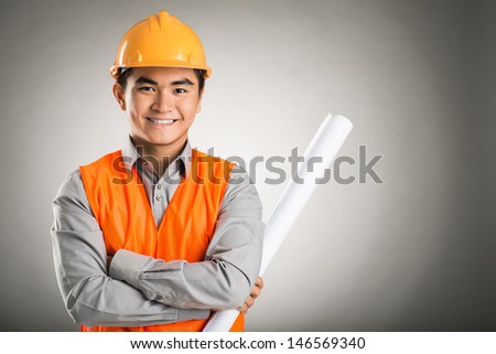 Portrait of a young confident engineer isolated on grey