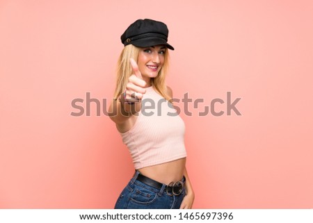 Young blonde woman with hat with thumbs up because something good has happened