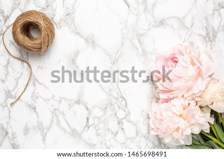 Marble background with pink flowers peony and twine