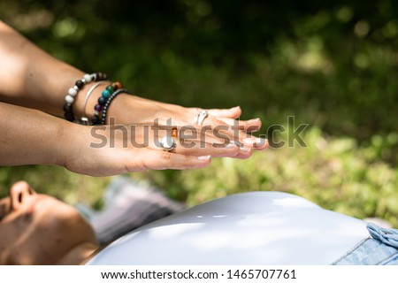 Reiki healers hands over a female's heart  Royalty-Free Stock Photo #1465707761