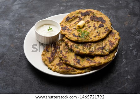 Thalipeeth is a type of savoury multi-grain pancake popular in Maharashtra, India served with curd/butter or ghee Royalty-Free Stock Photo #1465721792