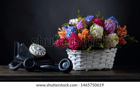 Bouquet of hyacinths in a white basket and a black retro phone.  Copy space.