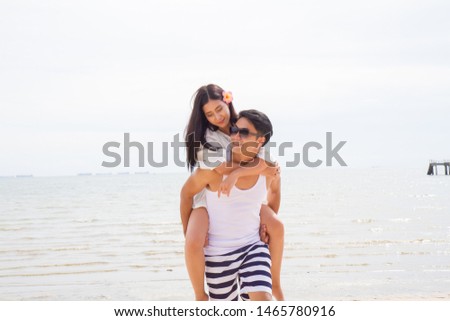 portrait guy carrying a girl on his back at the  Tropical Beach. family summer holidays or honeymoon - Image