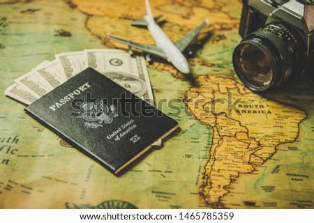 Tourist planning props and travel accessories with American passport, airplane, digital camera and US dollar banknote money on old grunge style map. Holiday and vacation. Tourism long weekend concept.