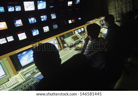 Rear view of operators in central control room at television station Royalty-Free Stock Photo #146581445