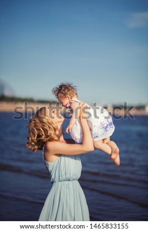People and family concept - Happy mom and daughter are relaxing on the beach against the background of the sea
