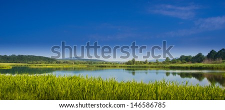 large lake in the middle of meadows in the spring