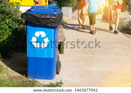Garbage collection. Waste recycling concept. Blue containers for further processing of garbage. Sunshine.
