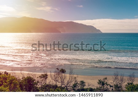 Picturesque coastline with mountains and sandy beach on sunset. Pirates Bay in Tasmania, Australia