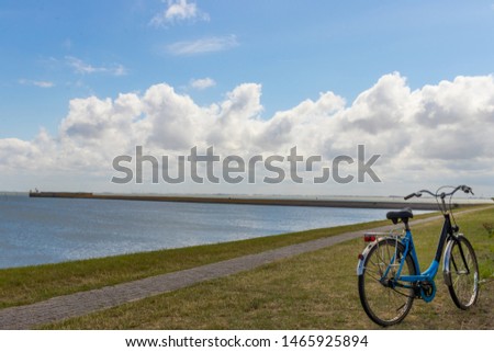 Beautiful landscape photography with a sky full of clouds above the ocean and a narrow path and a bicycle next to it