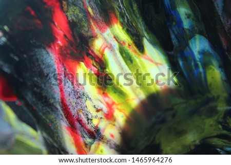 Cup with wet paint after acrylic paint pouring back light with rainbow colors. Colorful abstract background with high contrast Royalty-Free Stock Photo #1465964276
