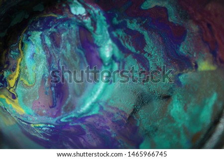 Cup with wet textured paint after acrylic paint pouring technique with shiny metallic colors. Aqua blue, purples, pinks, and lime greens. Colorful abstract background. Royalty-Free Stock Photo #1465966745