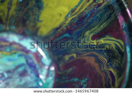 Cup with wet textured paint after acrylic paint pouring technique with shiny metallic colors. Aqua blue, purples, pinks, and lime greens. Colorful abstract background. Royalty-Free Stock Photo #1465967408