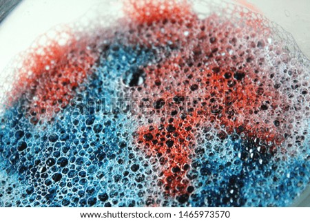 Red, white, and blue colored soap suds. Bright colored bubbles. Textured abstract background.  Royalty-Free Stock Photo #1465973570